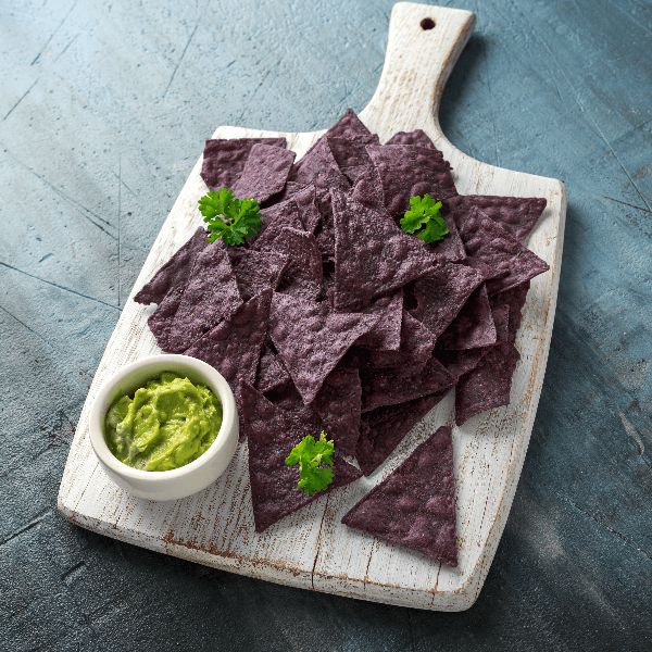 stock photo of wooden cutting board with blue corn tortilla chips