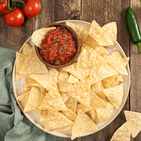 Overhead image of plate of tortilla chips with bowl of salsa.