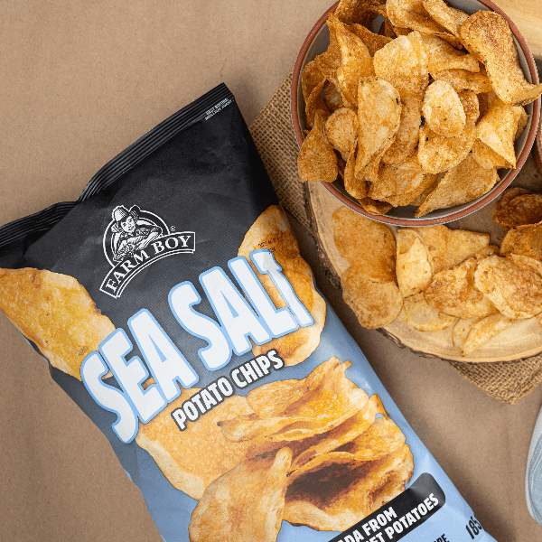 Overhead image of bag of Farm Boy Sea Salt Potato Chips beside bowl of chips.
