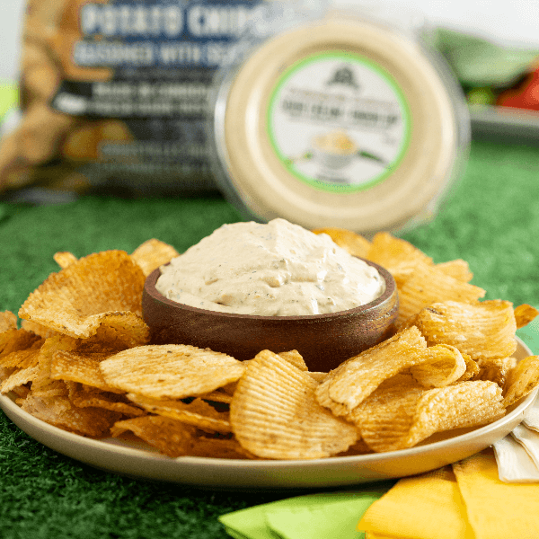 Plate of ruffled chips with bowl of Farm Boy Delightfully Delicious Sour Cream & Onion Dip.
